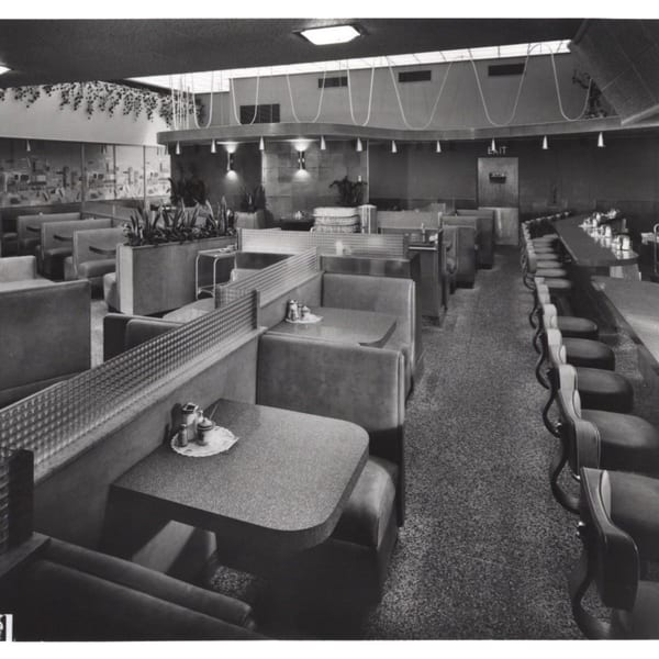 Black and white interior of Canter's Deli with booths, tables, and a long counter with stools.