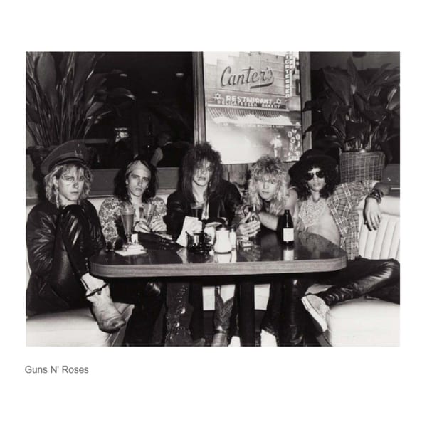 Guns N' Roses band members sitting at a table inside Canter's Deli, black and white.