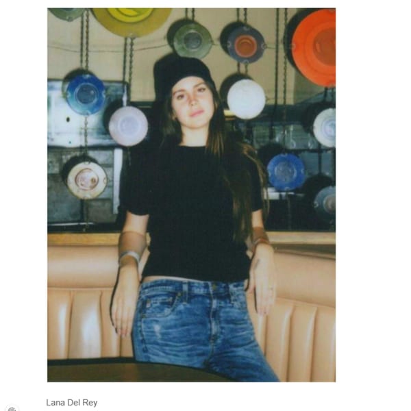 Lana Del Rey sits in a booth at Canter's Deli, surrounded by colorful decorative plates.