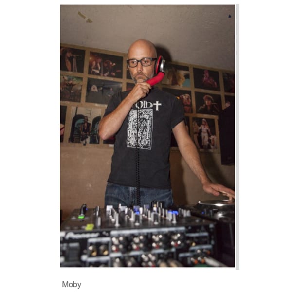 Moby, a bald man with glasses, DJing with red headphones at Canter's Deli.