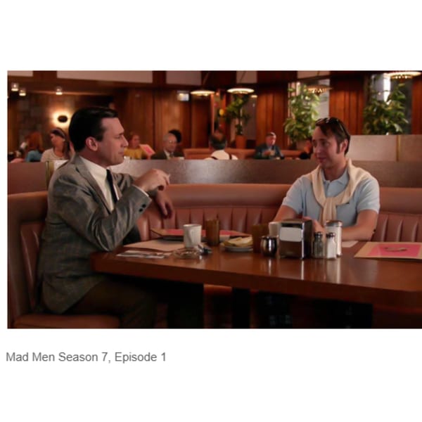 Two men in a booth at Canter's Deli, one in a suit, the other in a polo shirt.