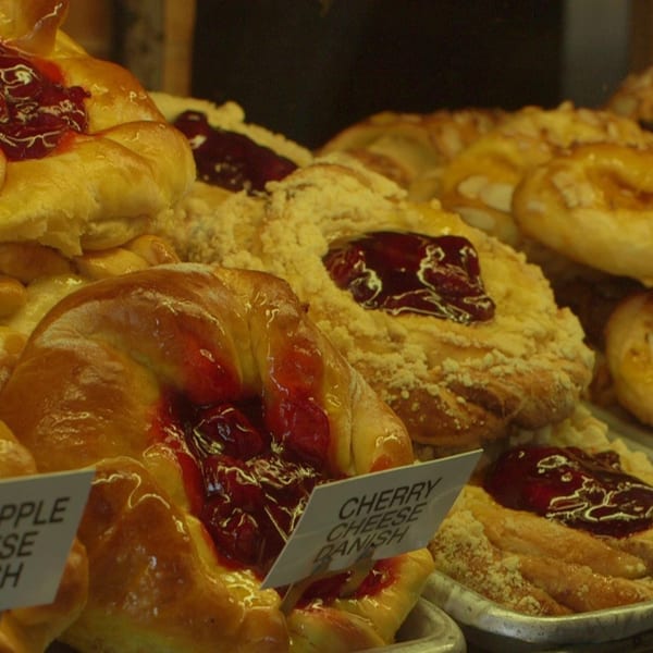 Canter's Deli display case filled with various fruit and cheese danishes, including cherry and apple.