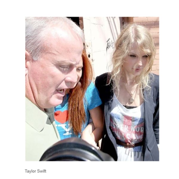 Taylor Swift, with blonde hair, wearing a white graphic tee and dark blazer, walks with two people.