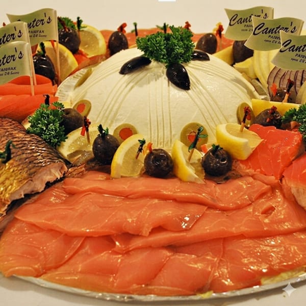 Canter's Deli platter with lox, smoked fish, cream cheese, olives, and lemon slices.