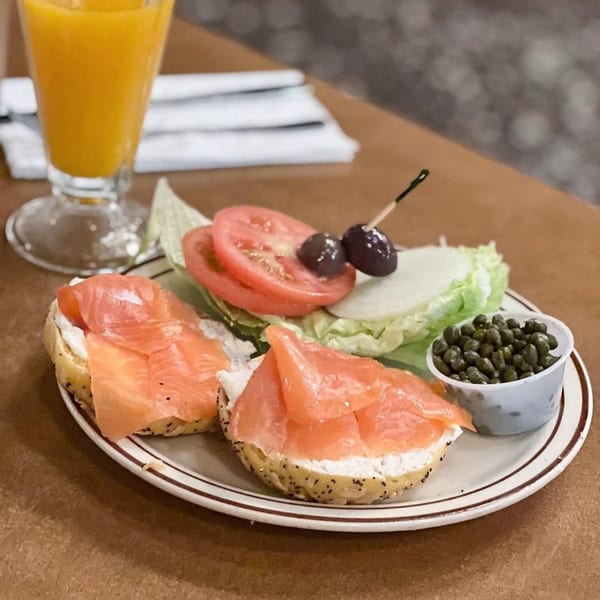Canter's Deli lox and cream cheese bagel with capers, tomato, lettuce, and orange juice.